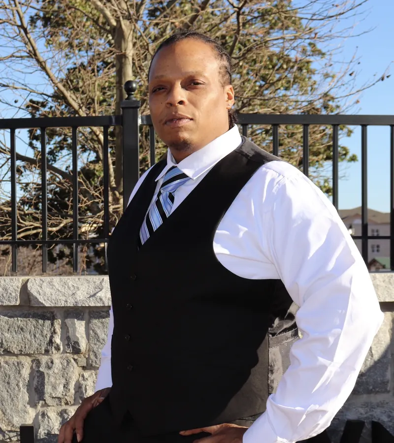 Phillip Hale, founder of SHYNZ, wearing a shirt, tie, and vest outdoors